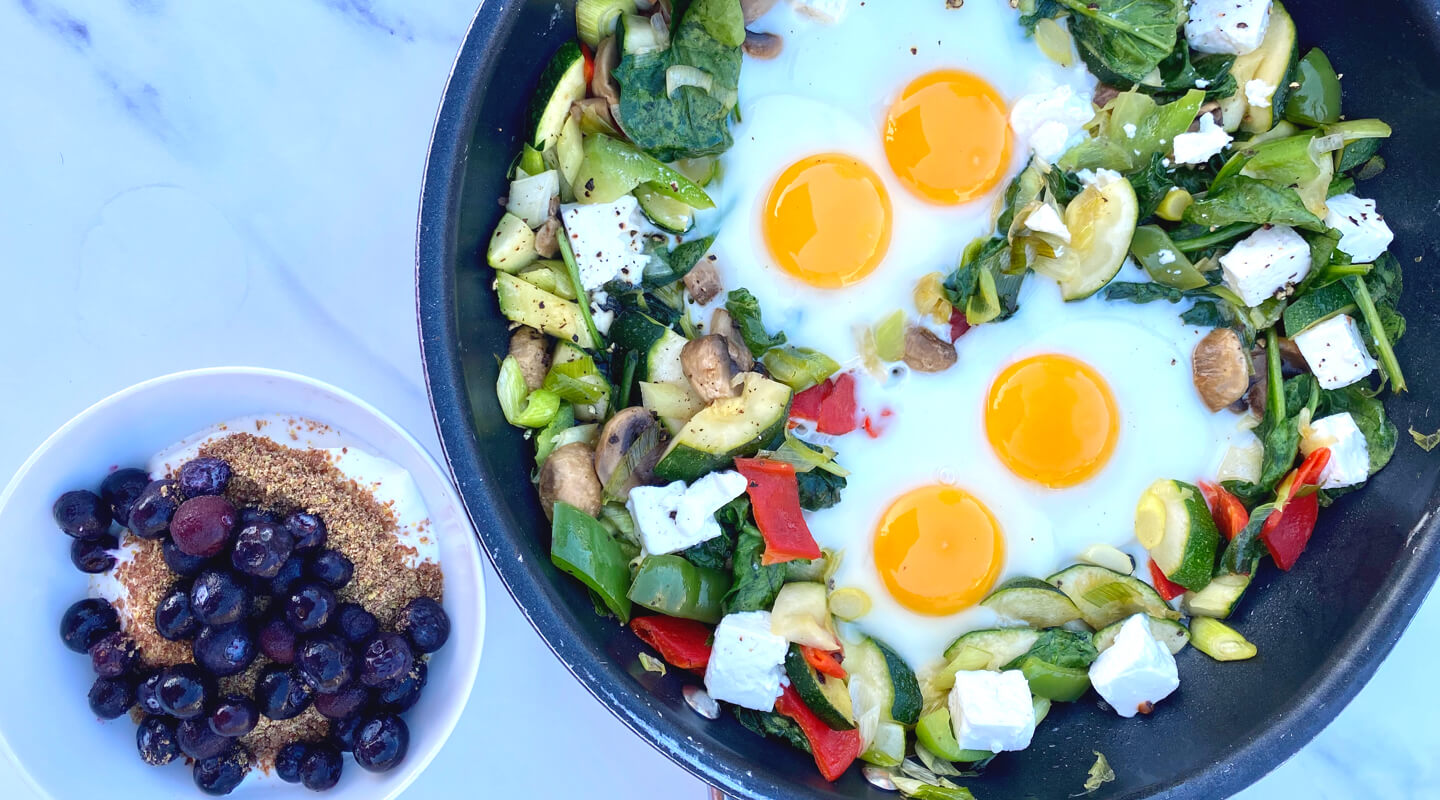 Healthy vegetarian breakfast with eggs in a pan