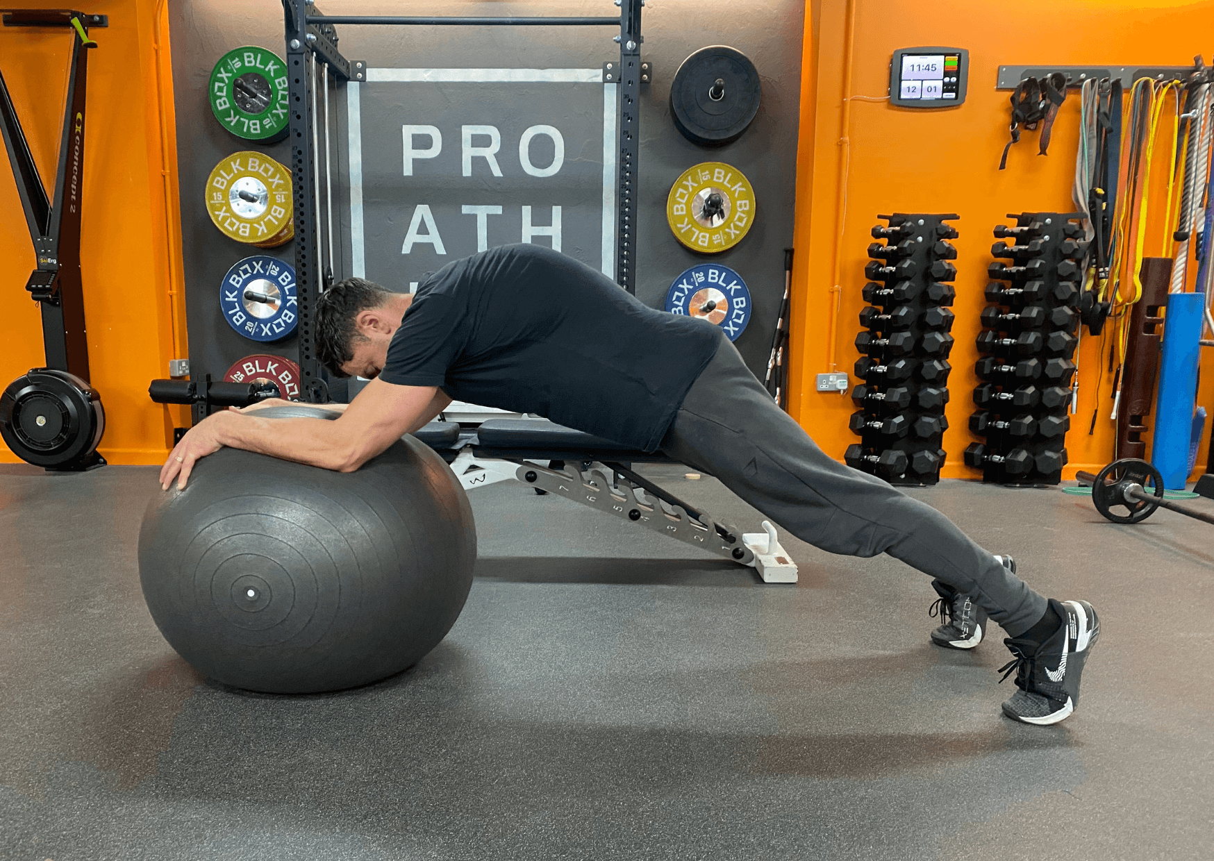 Trainer performing a stability ball roll out